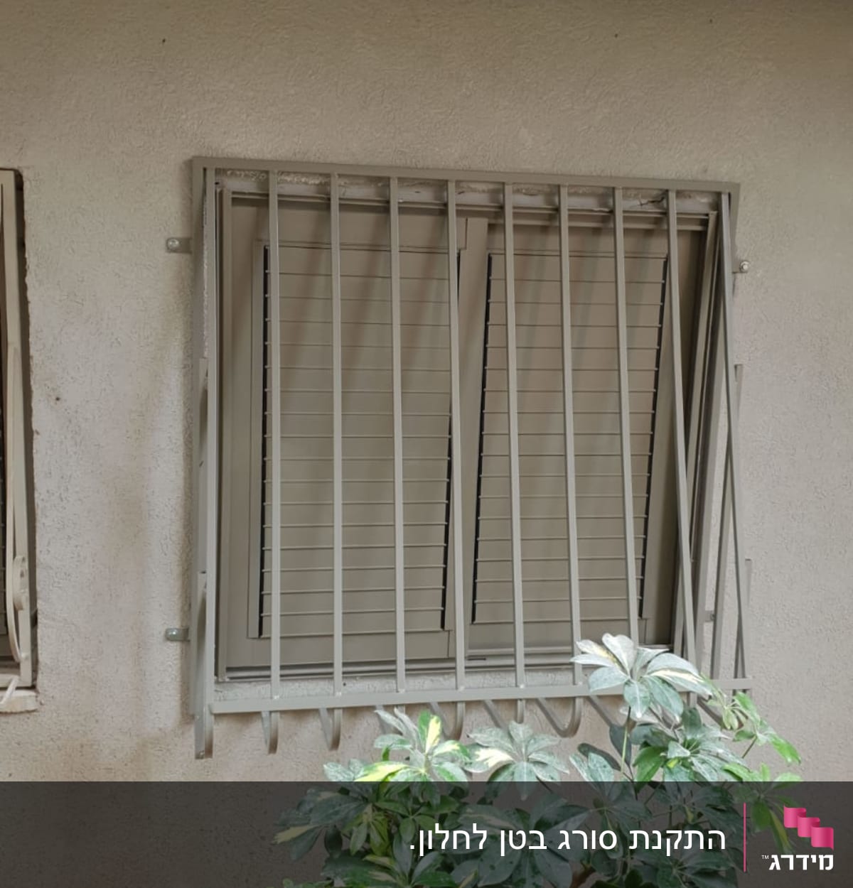 חלון עם סורגים ותריסים סגורים על קיר חיצוני